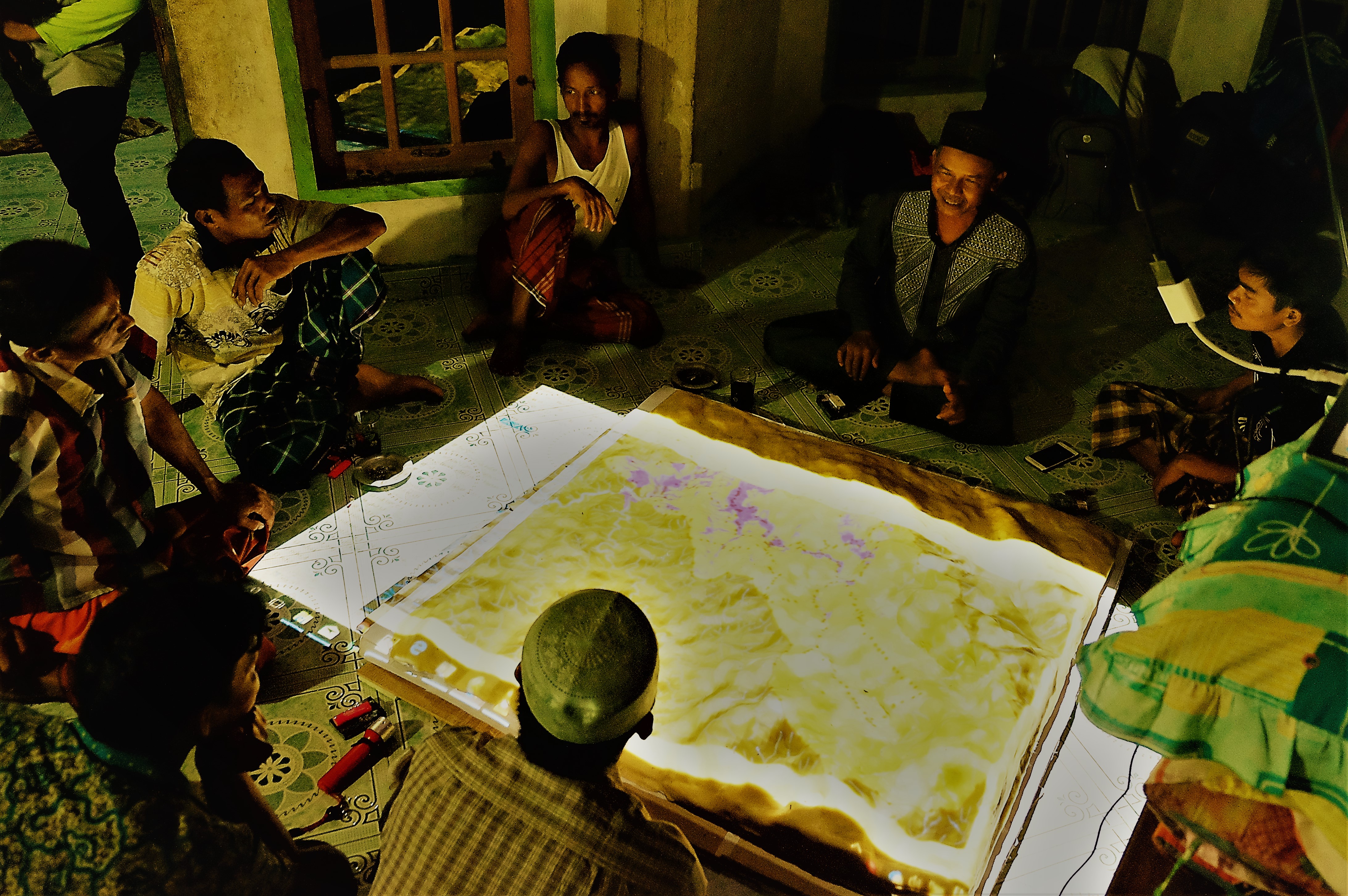 <p> Indigenous people in Gajah Bertalut, Kampar, Riau, observing 3D map models of their tribal lands. Photo by Julius Lawalata.</p>