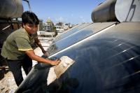 Wiping down rooftop solar panels in Mumbai. Flickr/The Climate Group