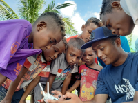 A researcher from WRI Indonesia explained how drone works to local children in West Papua. Photo credit: Rizky Haryanto/WRI