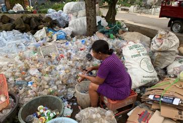 A woman work to collect plastic waste. 