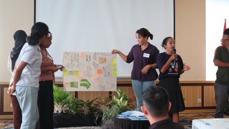 Osin (memegang mikrofon) dan kelompoknya menjelaskan hasil diskusi mereka sebagai ibu rumah tangga. 