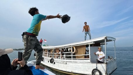 Pelemparan barang dari satu kapal ke kapal lain sebagai bentuk distribusi di pulau