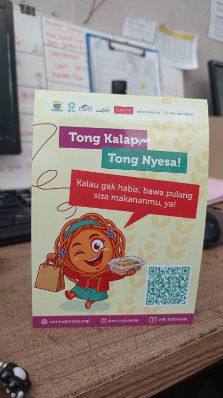 Tent card kampanye "Tong Kalap, Tong Nyesa" di meja kasir.