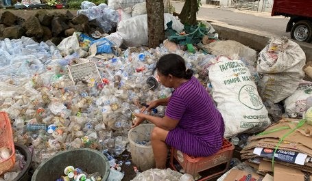 A woman work to collect plastic waste. 