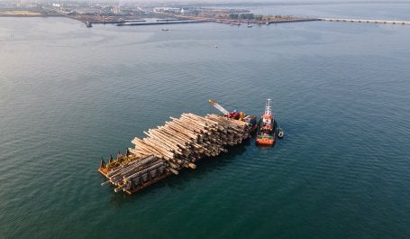 Pemandangan udara dari kapal yang membawa kayu gelondongan yang berlabuh di pantai