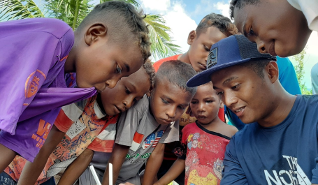 A researcher from WRI Indonesia explained how drone works to local children in West Papua. Photo credit: Rizky Haryanto/WRI