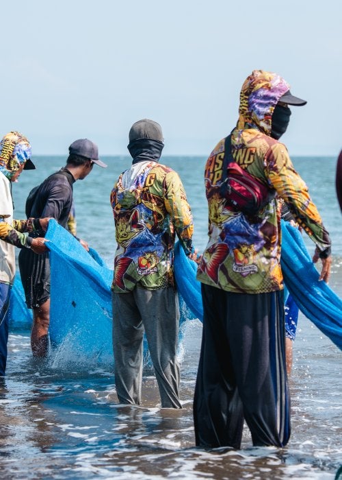 Fishermen taking out their nets at Jembrana Beach, Bali. 
