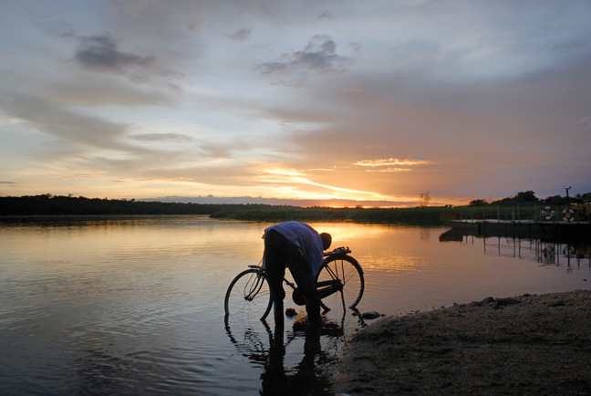 Man with bicycle at sunset